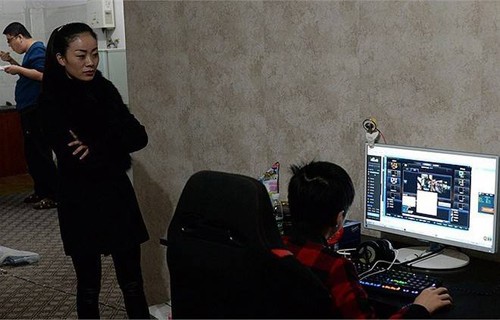 Mẹ của Tiểu Tânđang đứng xem con mình phát sóng trực tiếp buổi chơi game. Ảnh:Nownews. Mẹ của Tiểu Tânđang đứng xem con mình phát sóng trực tiếp buổi chơi game. Ảnh:Nownews.