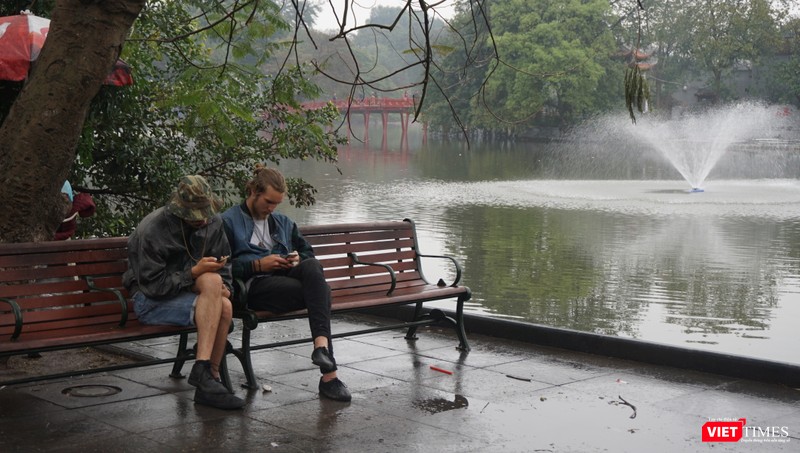 Khách du lịch tận hưởng khoảng lặng hiếm hoi trên đường phố Hà Nội.