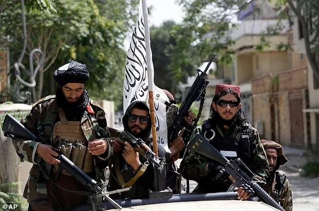 Lính Taliban mang quốc kỳ mới đi tuần trên đường phố Kabul hôm 19/8 (Ảnh: Dailymail).