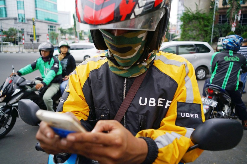 Jakarta, Indonesia: Một lái xe ôm Uber đang kiểm tra smartphone của mình, trong khi lái xe Go-Jek thì chở khách, phía bên phải là một xe ôm Grab. Ảnh: Straitstimes.com