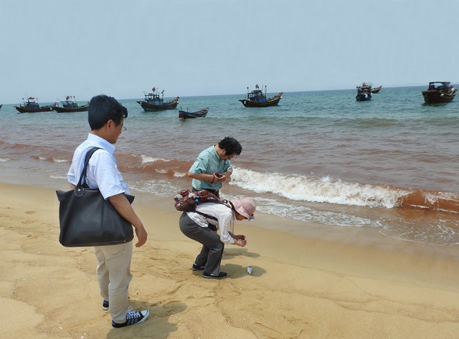 Cơ quan chức năng lấy mẫu nước tại vùng biển có màu đỏ để xét nghiệm - Ảnh: Nguyệt Anh