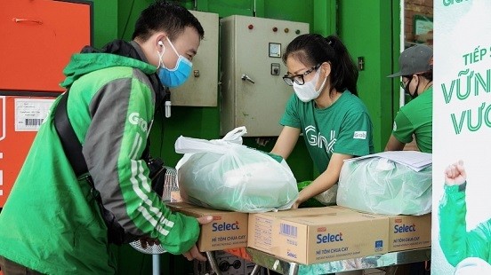 Bà Nguyễn Thái Hải Vân - Giám đốc Điều hành, Grab Việt Nam - tặng gạo và mì cho đối tác tài xế. Ảnh: Grab cung cấp.