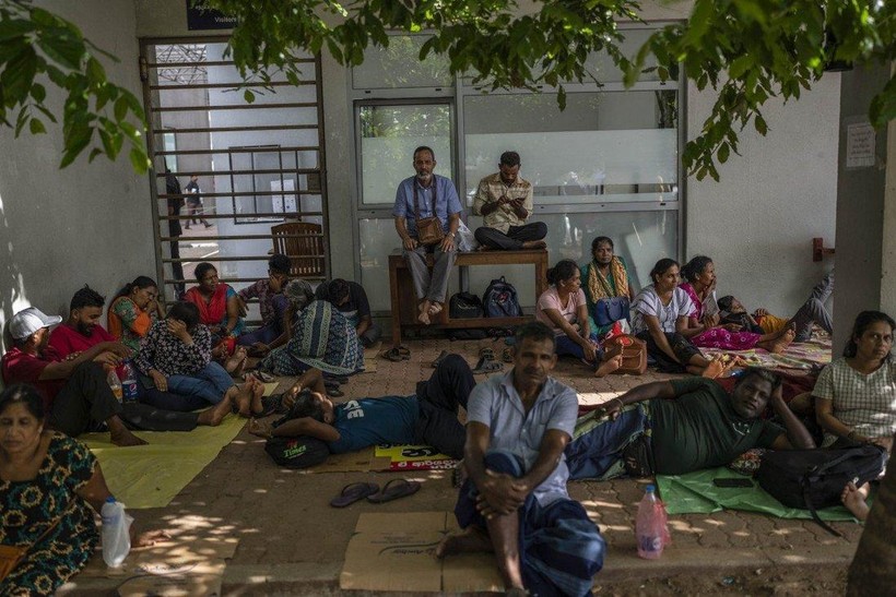 Nhiều người ngồi, nằm chờ trước cửa văn phòng di trú ở Colombo để xin hộ chiếu rời khỏi đất nước (Ảnh: AP)