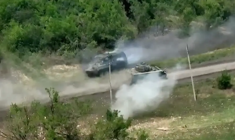 Ảnh cắt từ clip cho thấy xe chiến đấu Bradley do Mỹ cung cấp bắn vào xe bọc thép chở quân Nga (Ảnh: Business Insider)