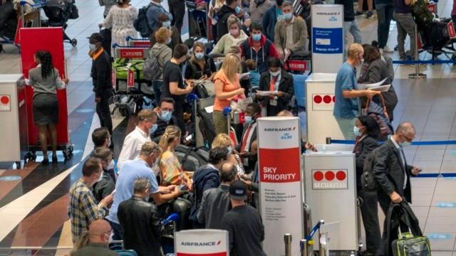 Du khách đổ xô ra sân bay về nước khi nhiều quốc gia thông báo lệnh cấm nhập cảnh với Nam Phi. Ảnh: AP