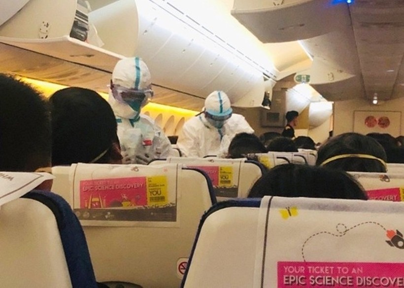 Các nhân viên y tế ơn sân bay Tiêu Sơn, Hàng Châu lên máy bay kiểm tra thân nhiệt của hành khách trên chuyển bay TR118 của háng Scoot (Ảnh: Đông Phương)