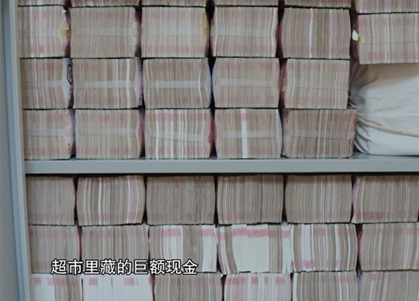 Nhiều bó tiền mới nguyên chưa được đụng tới trong tủ nhà Lại Tiểu Dân (Ảnh: CCTV).