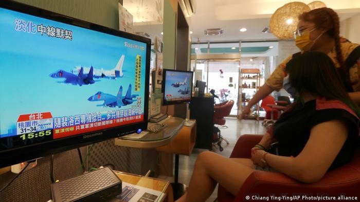 Dân chúng Đài Loan theo dõi cuộc tập trận của Quân đội Trung Quốc qua màn hình với tâm trạng bình thường (Ảnh: AP/Deutsche Welle).