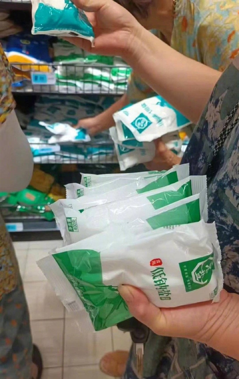 Một cư dân "tay xách nách mang" các loại muối (Ảnh: Sina) Cu dan dua nhau mua muoi.jpg