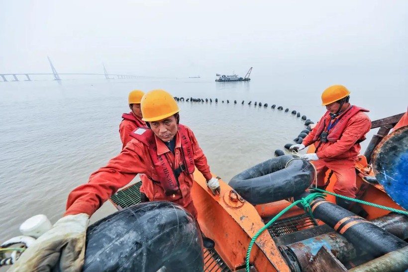 Công nhân thi công rải cáp ngầm trên biển (Ảnh: Sohu). Cong nhan rai cap ngam.jpeg