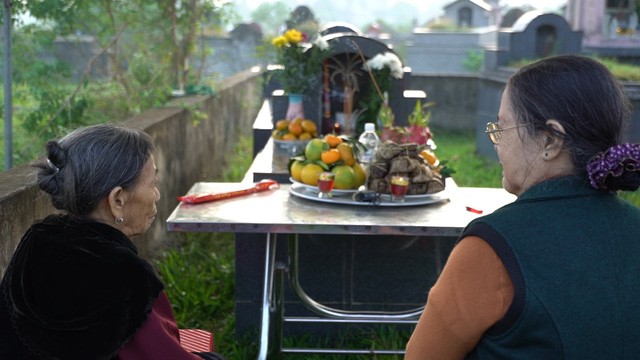 Hai người mẹ ngồi trước mộ con trước giờ khai quật (ảnh: VTV) Hai người mẹ ngồi trước mộ con trước giờ khai quật (ảnh: VTV)