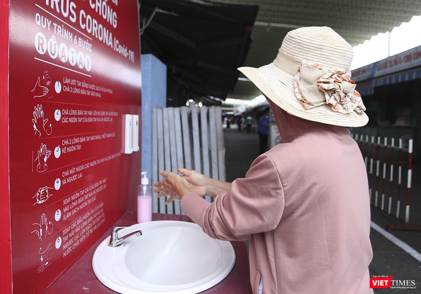 Người dân tuân thủ việc rửa tay, đeo khẩu trang trước khi vào chợ