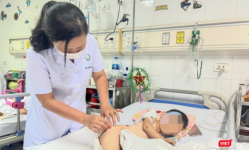 TS.BS Nguyễn Việt Hoa - Trưởng khoa Phẫu thuật Nhi và Trẻ sơ sinh, Bệnh viện Hữu nghị Việt Đức thăm khám cho bệnh nhi sau phẫu thuật