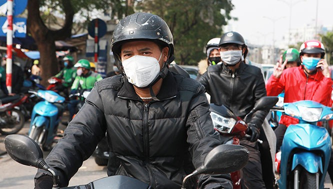 Người Việt đeo khẩu trang đi xe máy. Ảnh: