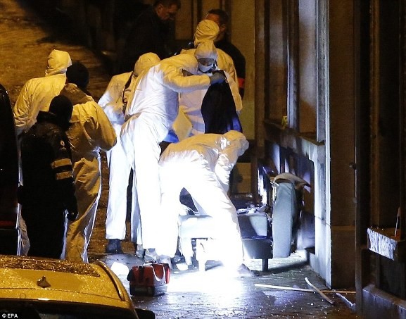 Chuyên gia pháp y của cảnh sát kiểm tra một chiếc ghế bành sau khi kéo nó ra ngoài đường bên ngoài trong số các tài sản đã bị tàn phá ở Verviers.