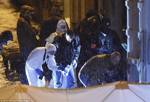 Cảnh sát và các điều tra pháp y làm việc dưới cơn mưa thu thập bằng chứng tại khu vực đã đánh dấu trong Rue de la Colline