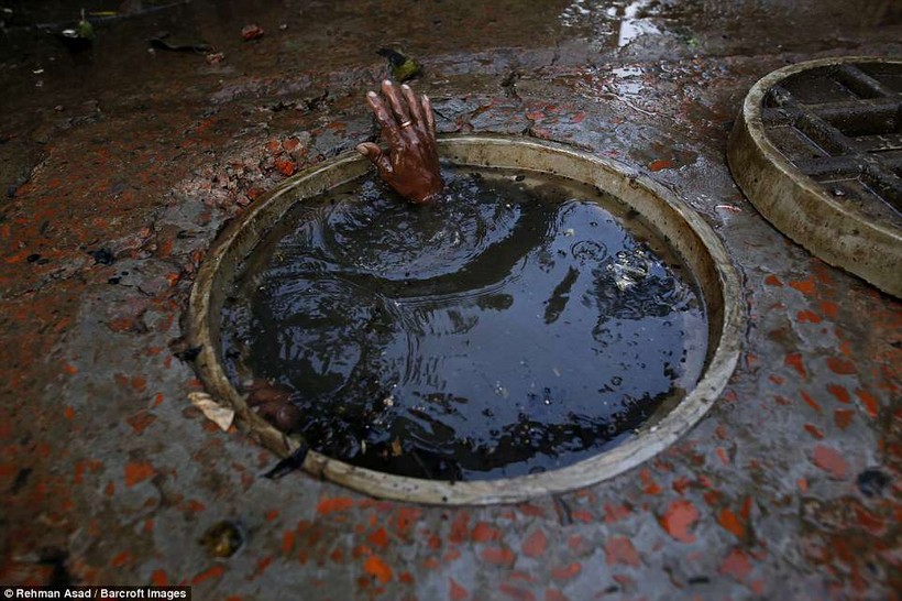 Họ chiến đấu với bùn đất được tạo ra trong các đường ống cống chật chội Họ chiến đấu với bùn đất được tạo ra trong các đường ống cống chật chội