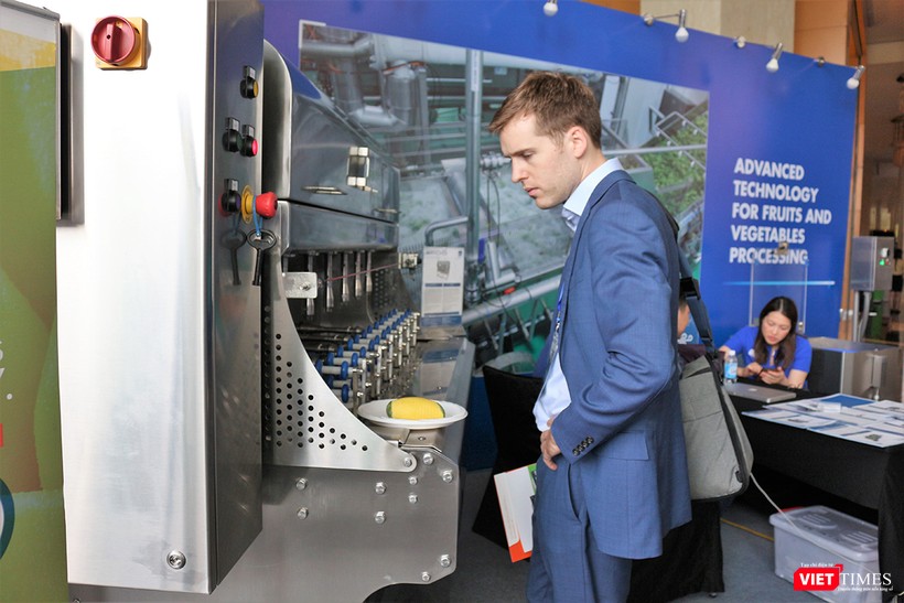 Một khách tham quan tò mò trước chiếc máy gọt hoa quả công nghiệp