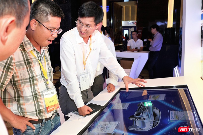 Đại diện VinFast giới thiệu đến khách tham quan triển lãm mẫu xe hơi của hãng