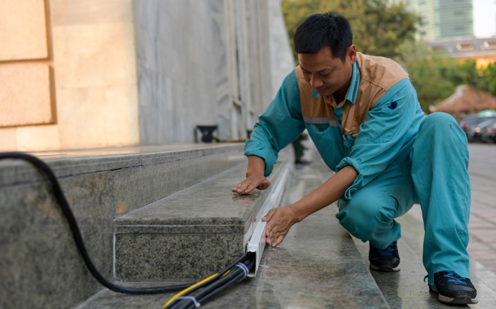 Nhân viên Viettel thực hiện triển khai hạ tầng mạng phục vụ phóng viên tác nghiệp tại Trung tâm báo chí Quốc tế. Ảnh: Viettel