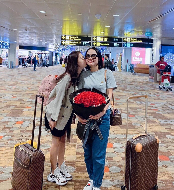 Trong bức ảnh chụp chung với mẹ, Huỳnh Anh đã khoe khéo cả vali lẫn túi hiệu Louis Vuitton với balo MCM và đôi sneaker Louis Vuitton archlight.