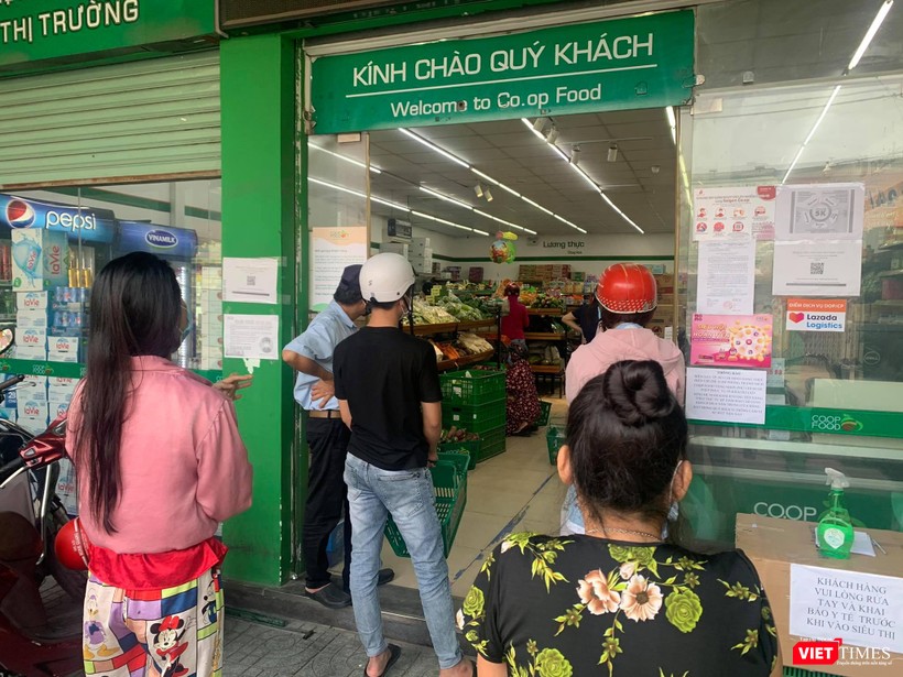 Xếp hàng giãn cách đợi đến lượt vào siêu thị Co.op Food mua thực phẩm - Ảnh: Hoà Bình