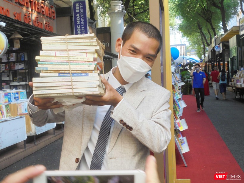 Chú rể Nguyễn Tú Anh hào hứng nhận từng chồng sách tặng. Ảnh: Hoà Bình