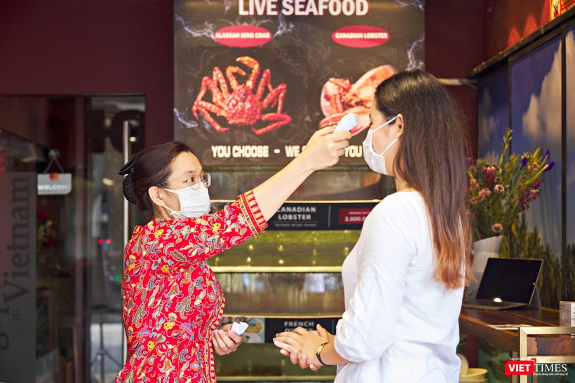Đo thân nhiệt cho khách vào nhà hàng, kiểm tra khai báo y tế, thẻ xanh COVID-19. Ảnh: HB