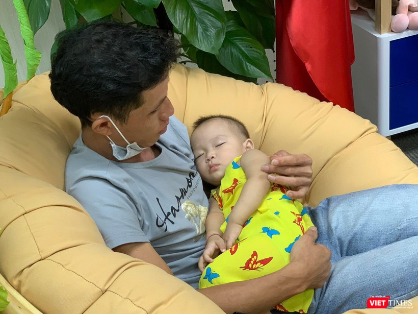 Em bé vừa tròn tuổi, mạnh khỏe, ngủ ngoan trong vòng tay bố.