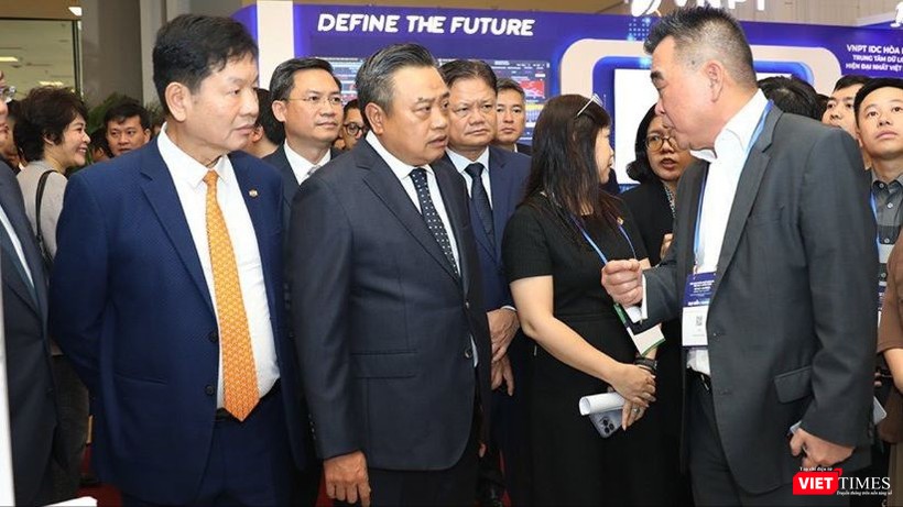 Chủ tịch TP Hà Nội Trần Sỹ Thanh trao đổi với các doanh nghiệp trình diễn giải pháp tại triển lãm trong khuôn khổ hội nghị. vt_trien lam 2.jpg