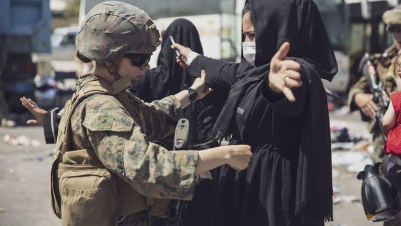 Một người phụ nữ được kiểm tra an ninh tại Trung tâm Kiểm soát Sơ tán (EEC) tại sân bay Kabul (Ảnh: Reuters)