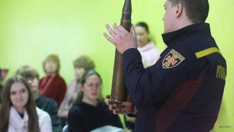 Nhân viên quốc phòng Ukraine đang hướng dẫn các học sinh nhận biết những vũ khí gây nổ. Ảnh: REUTERS