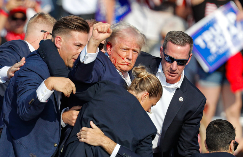 Donald Trump được các nhân viên mật vụ vội vã đưa ra khỏi sân khấu sau vụ nổ súng tại cuộc vận động tranh cử ở Pennsylvania (Ảnh: EPA) 2.png