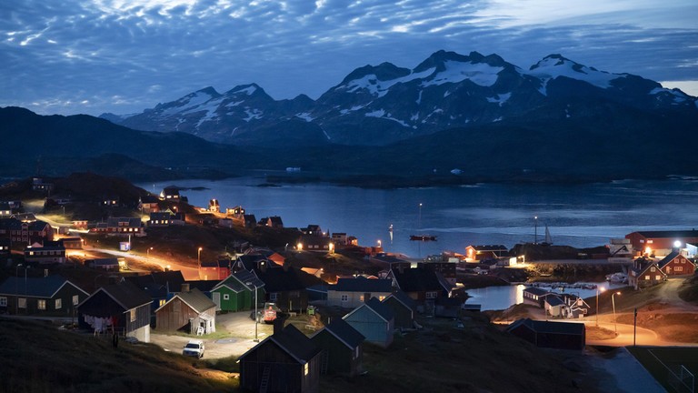 Những ngôi nhà lên đèn sau khi mặt trời lặn ở Tasiilaq, Greenland. Ảnh: Getty.