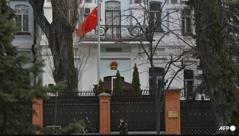Một người phụ nữ đi ngang qua tòa nhà Đại sứ quán Trung Quốc tại Kiev vào ngày 8/4. Ảnh: AFP.