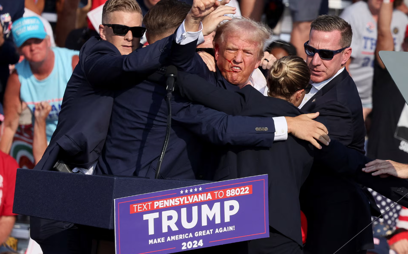 Ông Donald Trump ra hiệu với khuôn mặt đầy máu sau khi bị bắn vào tai phải trong một cuộc vận động tranh cử ở Butler, Pennsylvania, Mỹ ngày 13/7/2024. Ảnh: Reuters.