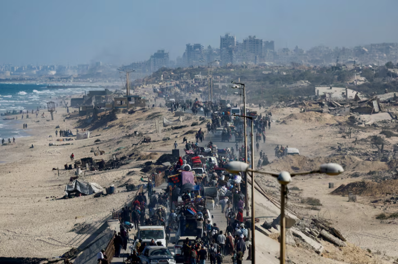 Người dân Palestine, những người phải di dời đến phía nam Gaza theo lệnh của Israel, di chuyển dọc theo một con đường khi họ trở về phía bắc, trong bối cảnh lệnh ngừng bắn giữa Israel và Hamas ở Gaza, ngày 11/10. Ảnh: Reuters.