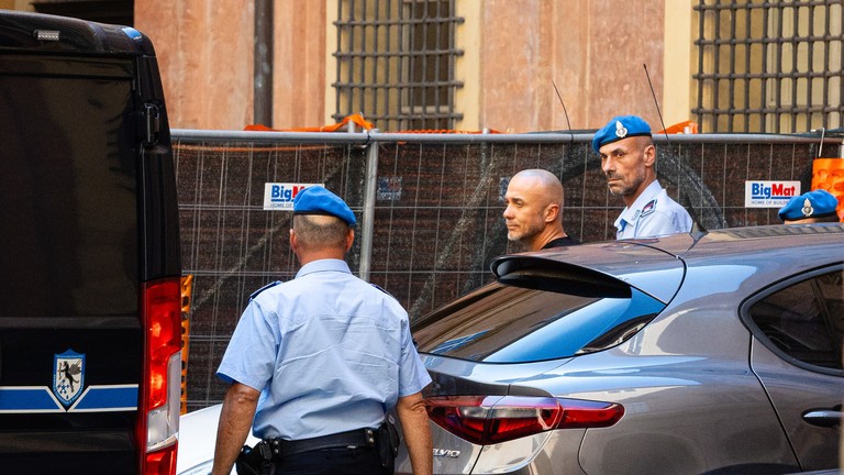 Cảnh sát áp giải nghi phạm đánh bom đường ống Nord Stream Sergey Kuznetsov tại Bologna, Italy vào ngày 22/8. Ảnh: Getty.