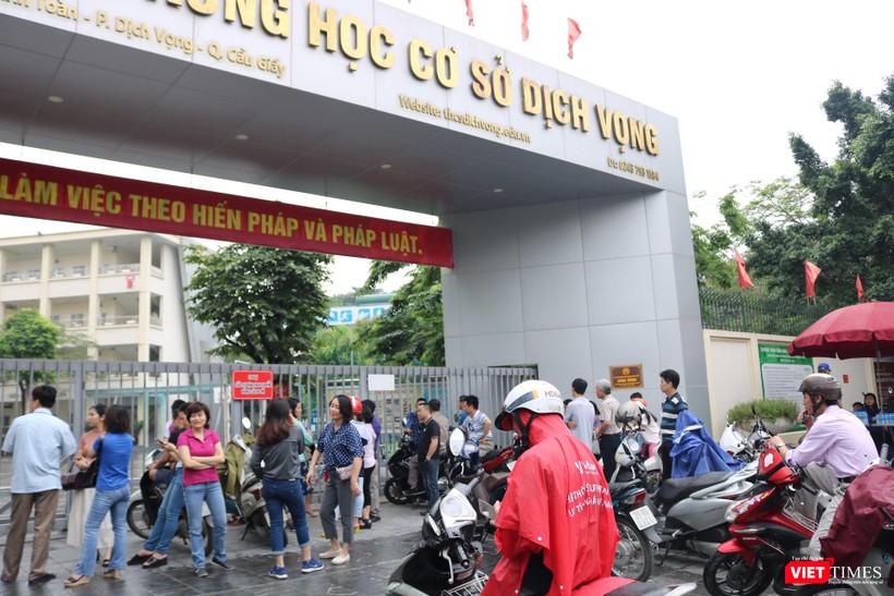 Nhiều phụ huynh đội mưa đưa con đi thi . Ảnh: Minh Thúy