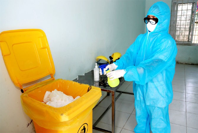 Nhân viên y tế xử lý rác ở khu cách ly (Ảnh - BYT)