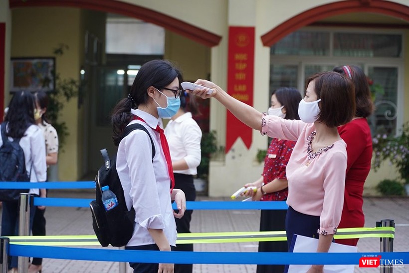 Cán bộ Trường THPT Phan Đình Giót đo thân nhiệt cho học sinh. Ảnh: Minh Nhân