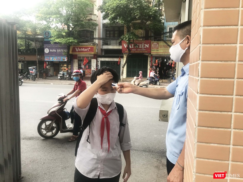 Kiểm tra thân nhiệt trước khi vào lớp. Ảnh: Hiếu Nguyễn