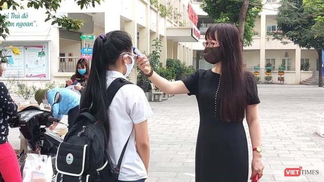Cô giáo đo nhiệt độ cho học sinh (Ảnh- Minh Thuý)