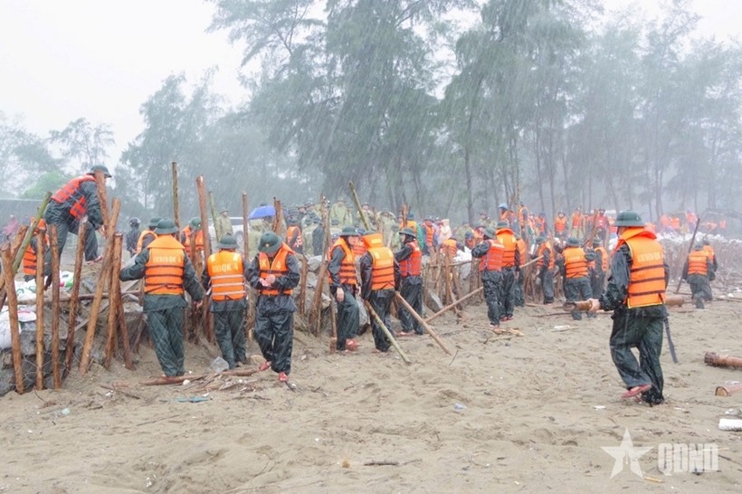 Hơn 200 cán bộ, chiến sĩ lực lượng vũ trang tỉnh Hà Tĩnh hộ đê trong mưa to, gió lớn. Ảnh: Báo Quân đội nhân dân.