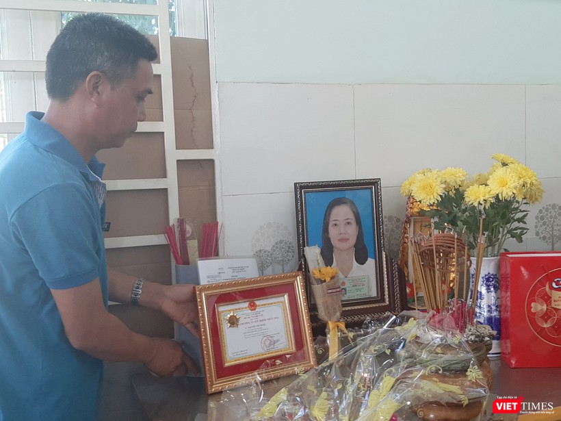 Anh Trần Bá Trình trân trọng đặt bằng khen của Bộ Y tế lên bàn thờ người vợ quá cố. Ảnh: Nguyễn Trăm