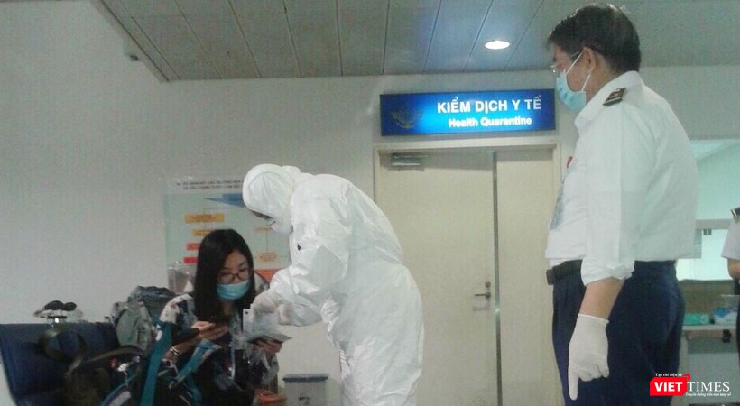 Nhân viên mặc đồ bảo hộ khi tiếp xúc với hành khách thuộc diện cách ly. Ảnh: H.U