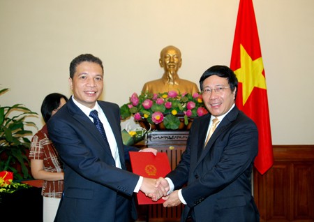 Phó Thủ tướng Chính phủ, Bộ trưởng Ngoại giao Phạm Bình Minh trao Quyết định cho ông Đặng Minh Khôi. Ảnh: Quang Hòa/TG&VN