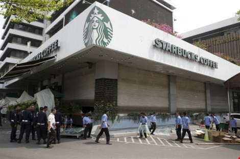 Công nhân dọn dẹp các mảnh vỡ bên ngoài quán cà phê Starbucks, gần khu vực tấn công hôm thứ Năm tại Jakarta.
