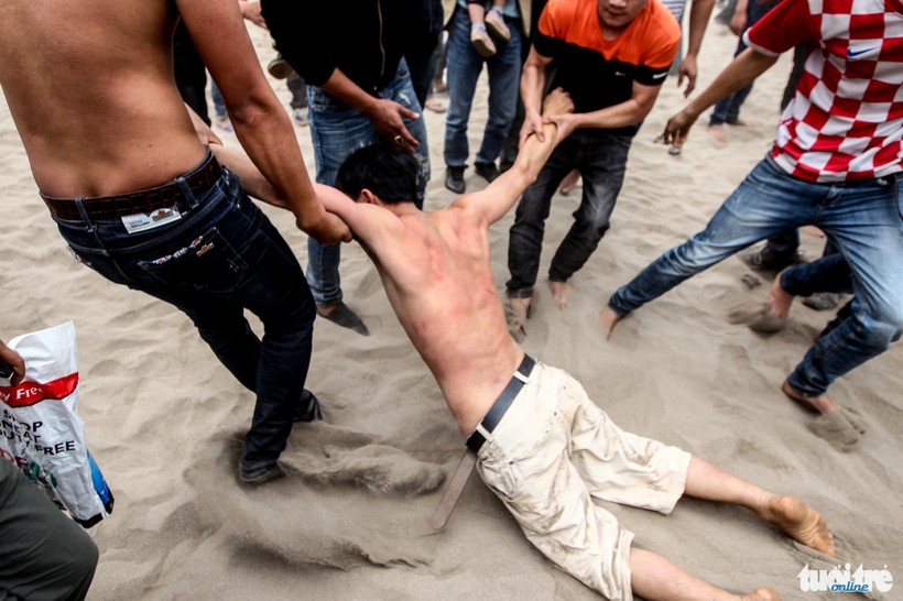 Thanh niên này bị ngất xỉu đang được đồng đội kéo ra khỏi đám đông hỗn loạn - Ảnh: Nguyễn Khánh