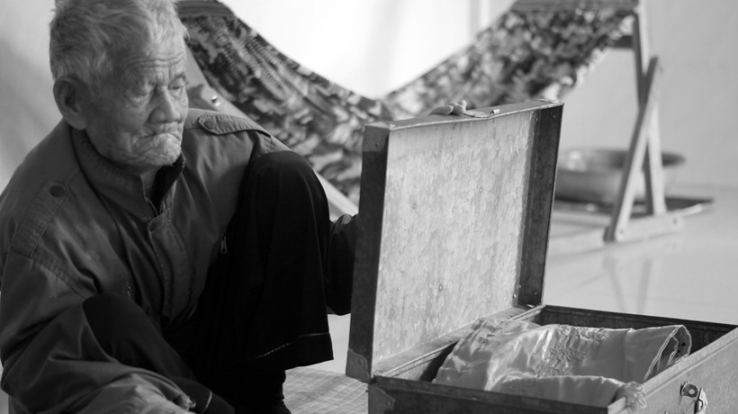 Ông Nhỏ bên chiếc rương cũ đã hoen gỉ, kỷ vật còn sót lại của liệt sỹ Túy. Chiếc rương này nay được ông dùng để đựng áo quan, dành cho tang lễ của chính mình.